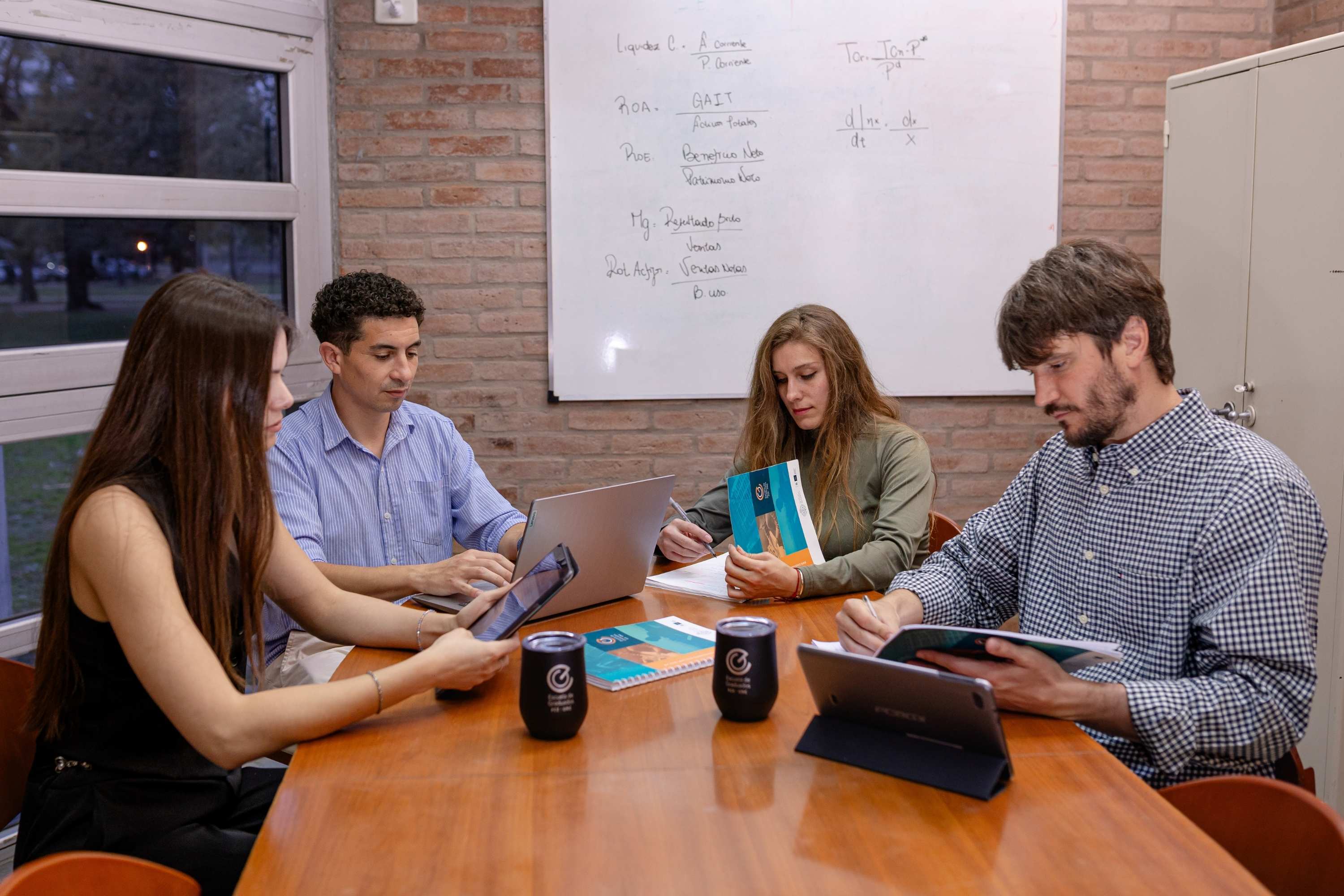 graduados estudiantes leyendo mesa 300x220