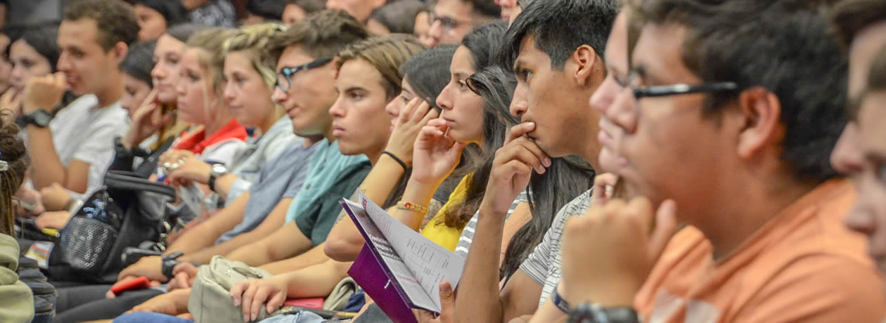 Chicos y chicas sentados mirando al frente muy atentos