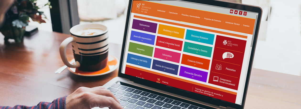 Una computadora portátil y una persona navegando en la web de la Secretaría de Extensión