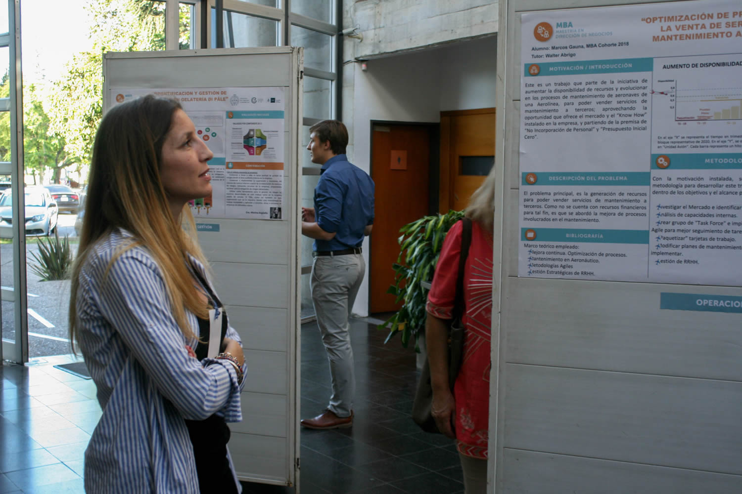 Estudiantes exponiendo en el hall central de la Escuela de Graduados