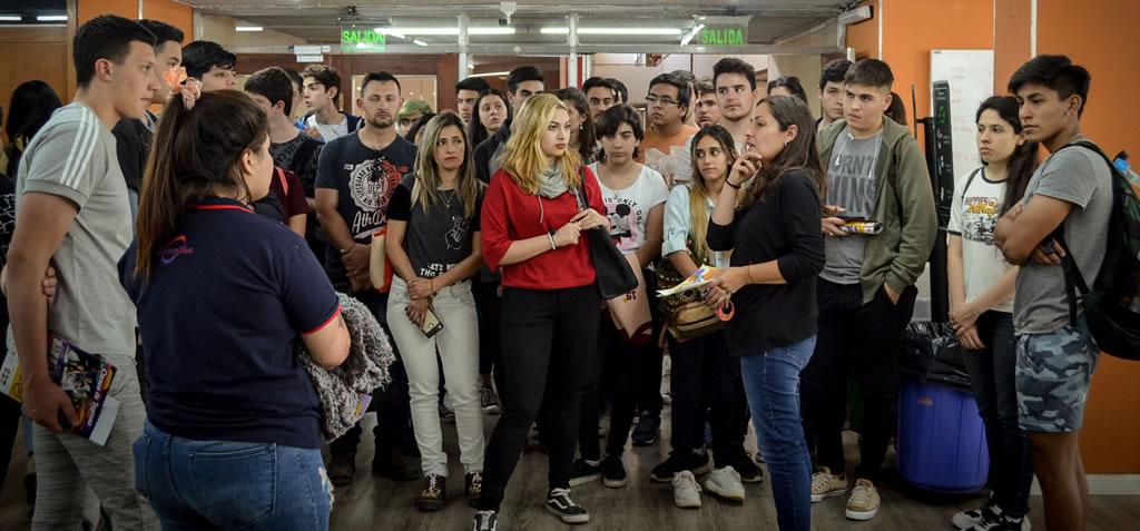 La licenciada Tatiana Rodríguez Castagno guía a los jóvenes dentro de la Biblioteca Manuel Belgrano de la Facultad