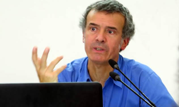 Foto de Jorge Rodríguez Vignoli con camisa azul disertando frente a un micrófono