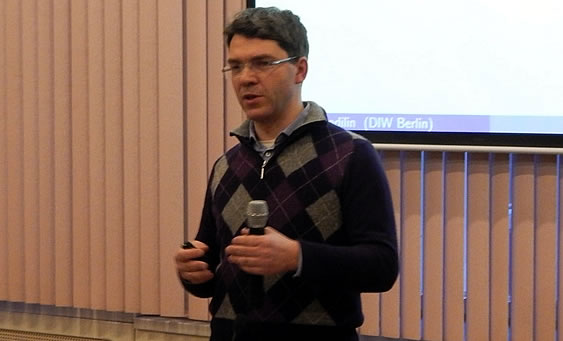 Imagen del profesor Kholodilin exponiendo con un micrófono en su mano izquierda