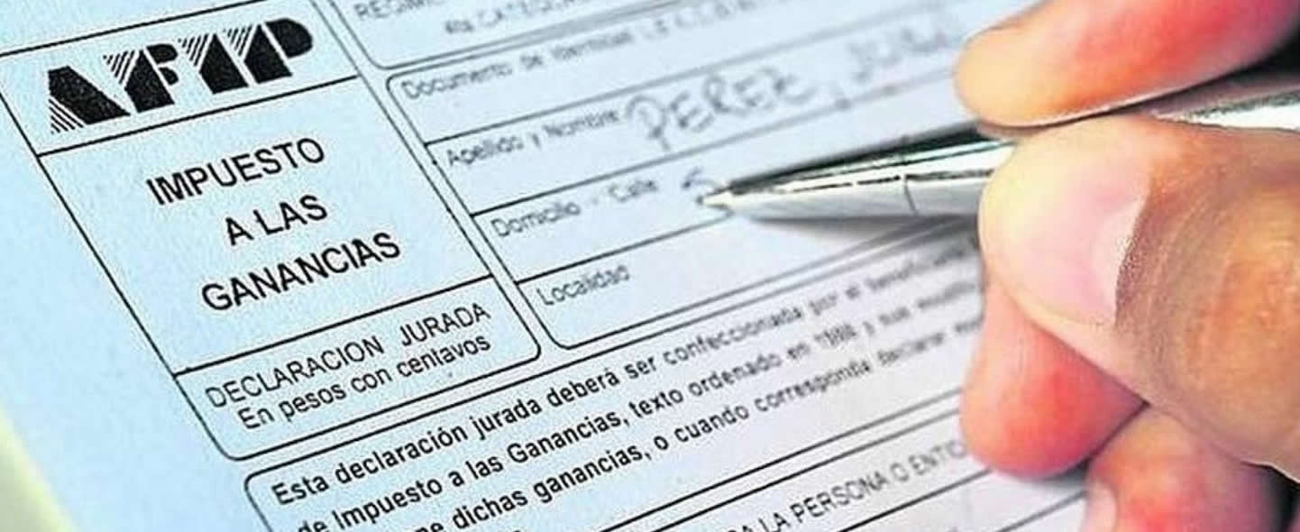 La mano de un varón con una lapicera llenando un formulario de AFIP