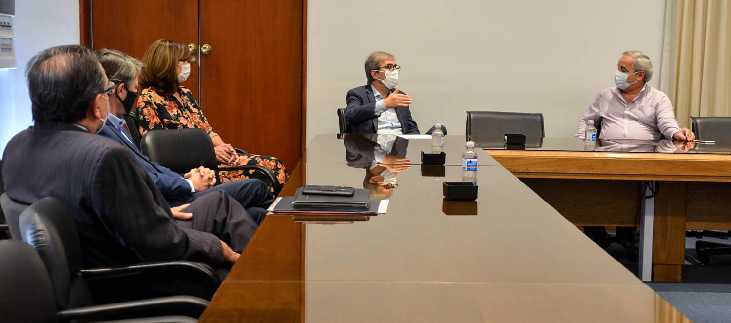 El Decano conversando con el presidente del Consejo Profesional ante la mirada de la Vicedecana, el coordinador de la Red Graduados y el profesor Titular del Seminario de Actuación Profesional, todos sentados y con distanciamiento usando barbijos