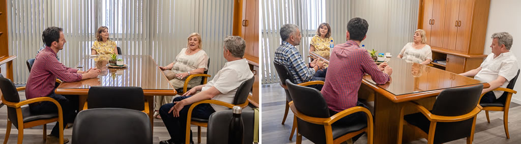 Las cinco autoridades reunidas sentadas en sillas y hay una gran mesa de madera