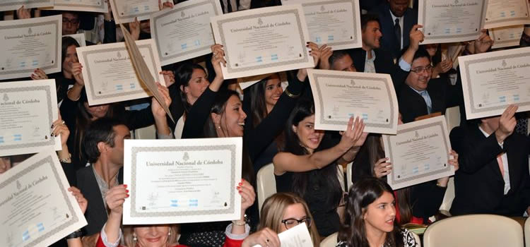 Imagen de un acto de colación de grados, con los egresados con sus diplomas en alto