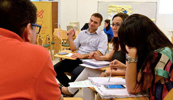Imagen de un grupo de estudiantes trabajando en una ronda dentro de un aula de la Secretaría de Extensión