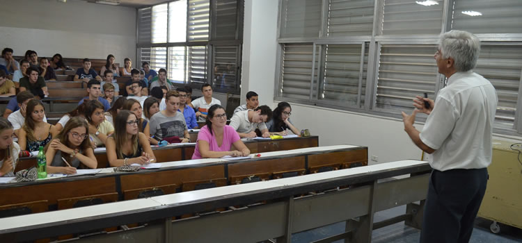 Imagen del profesor Enrique Neder dando clases frente a muchos estudiantes sentados