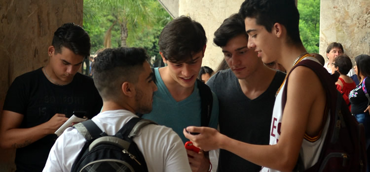 Cuatro jóvenes estudiantes reunidos en la explanada del Pabellón Argentina compartiendo una conversación