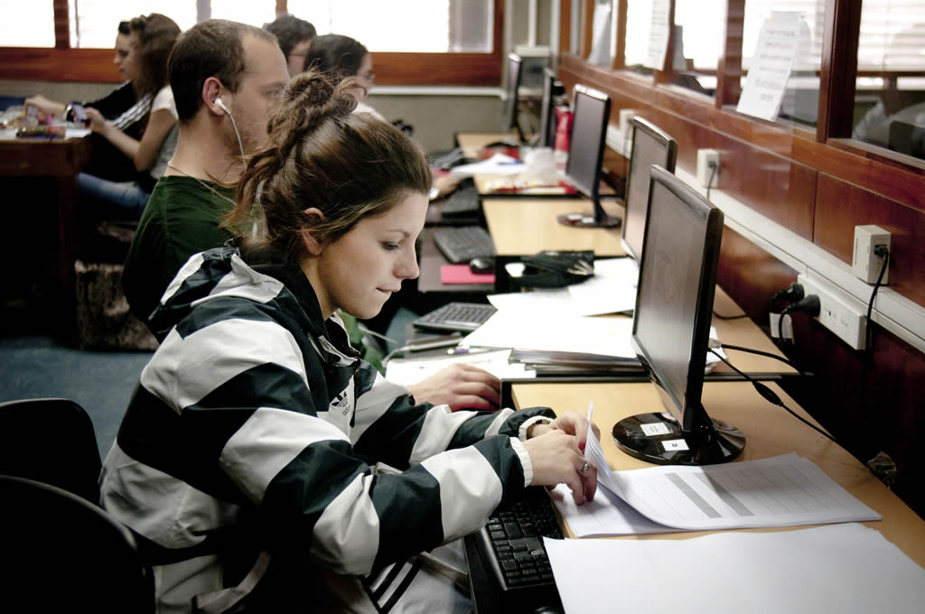 Imagen de estudiante realizando un trámite frente a la pantalla