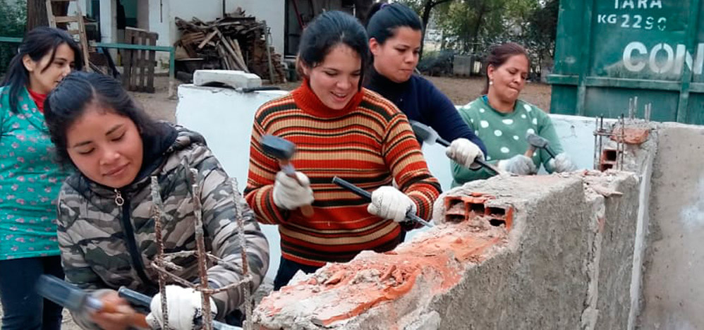 Imagen de mujeres alumnas de la Escuela de Oficios de la UNC haciendo trabajos de albañilería