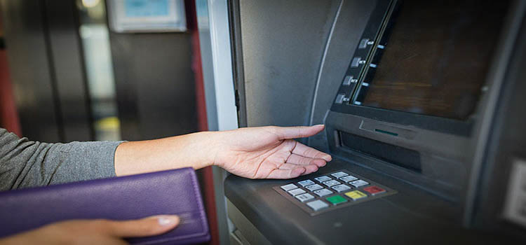 Imagen de una señora retirando dinero de un cajero automático