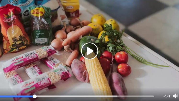 Reproductor del video que muestra verduras y paquetes de alimentos sobre una mesa