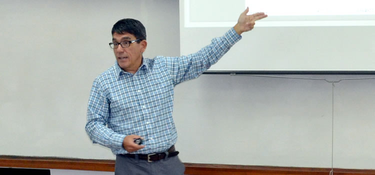 Jorge Paz exponiendo y señalando una imagen en un pizarrón blanco
