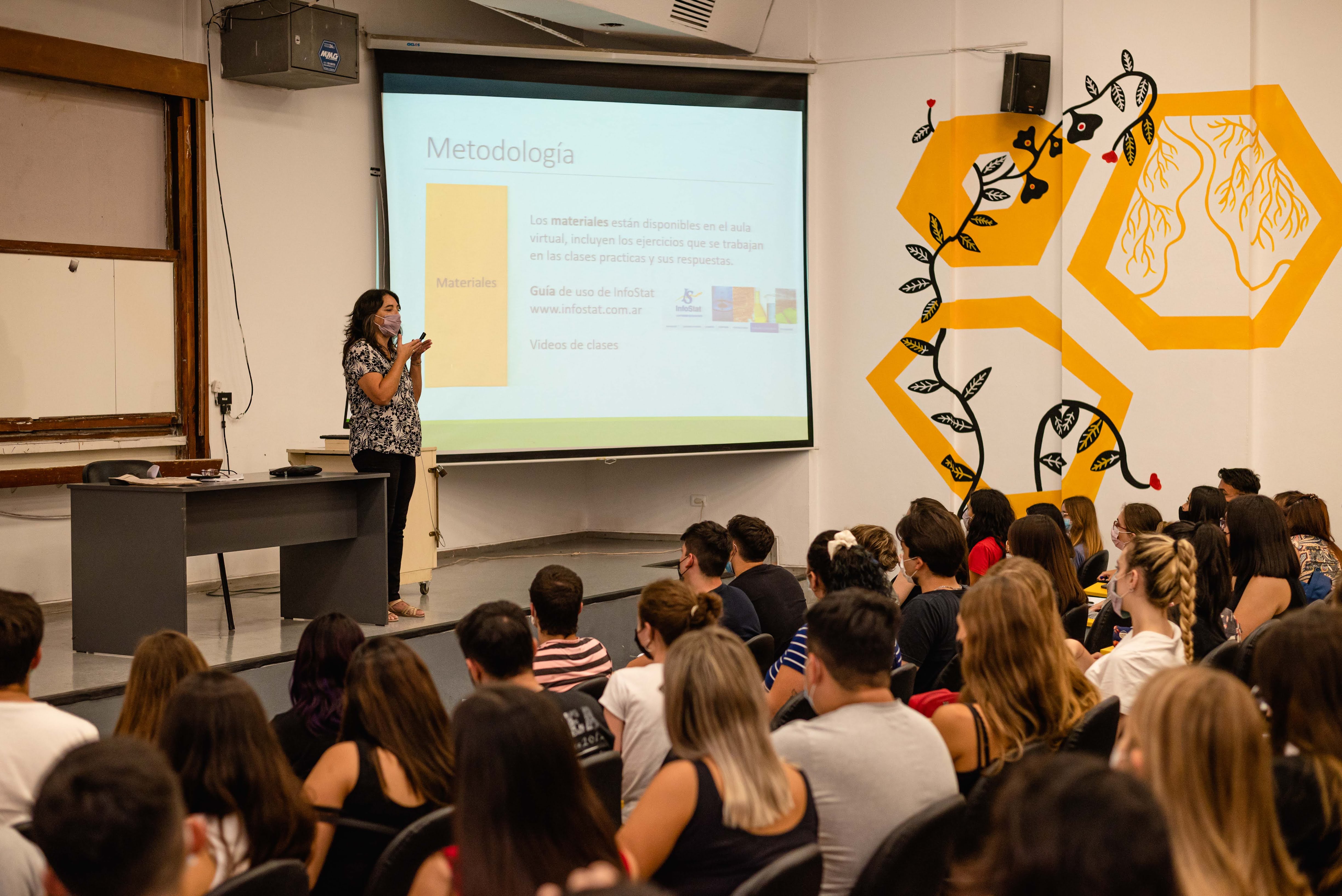 Foto de docente dando clase en aula híbrida